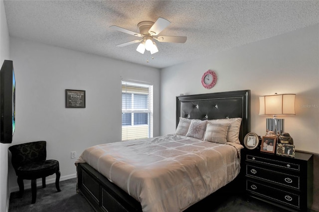 bedroom featuring a textured ceiling, dark carpet, and ceiling fan