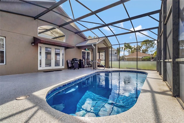 view of swimming pool featuring french doors, glass enclosure, and a patio area