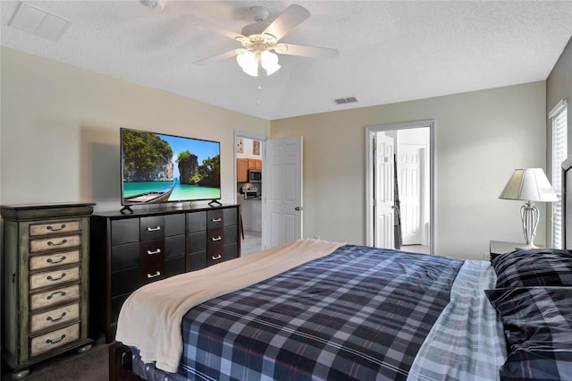 carpeted bedroom featuring ceiling fan and a textured ceiling