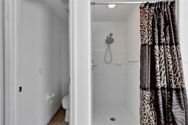 bathroom featuring toilet, tile patterned floors, and curtained shower