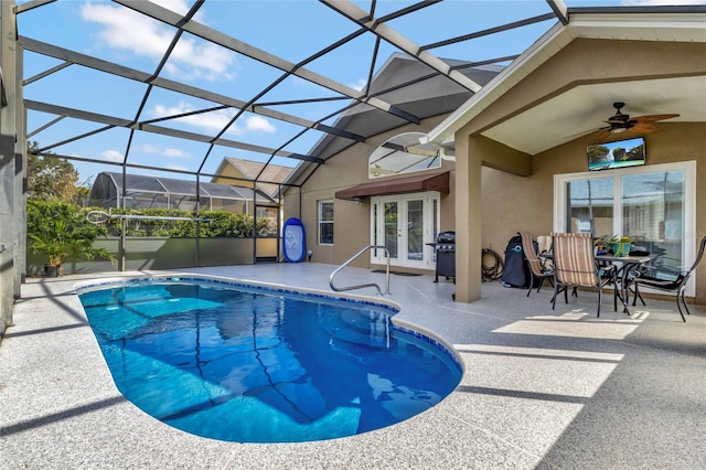 view of swimming pool featuring ceiling fan, a lanai, french doors, and a patio area