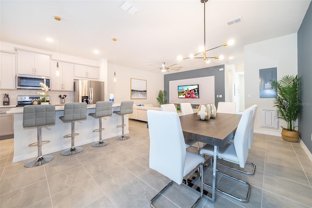 dining space featuring light tile patterned floors and ceiling fan with notable chandelier