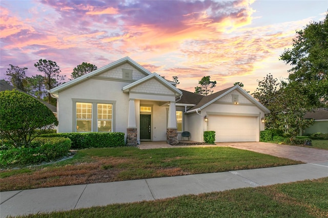 view of front of property with a garage and a yard