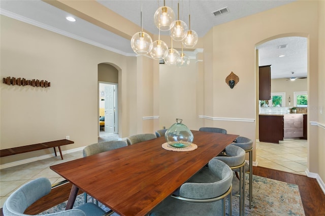 dining room featuring ceiling fan, a textured ceiling, light hardwood / wood-style flooring, and crown molding