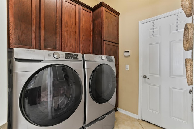 washroom featuring cabinets, light tile patterned flooring, and separate washer and dryer