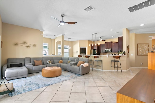 tiled living room with crown molding, a textured ceiling, and ceiling fan