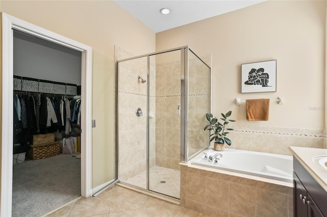 bathroom featuring shower with separate bathtub, vanity, and tile patterned flooring