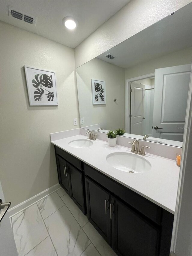 1144 Challenge Dr, Davenport, FL 33896 - full bathroom featuring baseboards, double vanity, and marble look tiles
