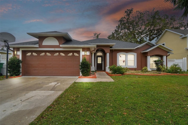 view of front of property with a garage and a lawn