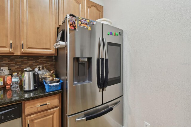 kitchen with dark stone counters, backsplash, and stainless steel appliances