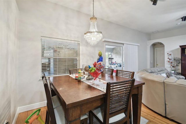 dining room with an inviting chandelier and light hardwood / wood-style flooring