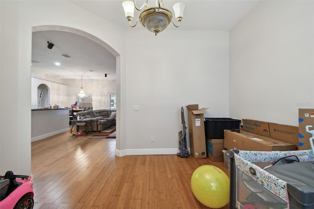 bedroom with a chandelier and light hardwood / wood-style floors