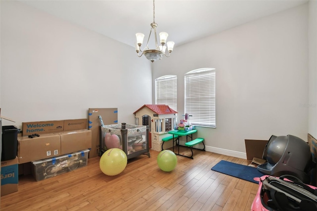 playroom featuring light hardwood / wood-style flooring and a notable chandelier