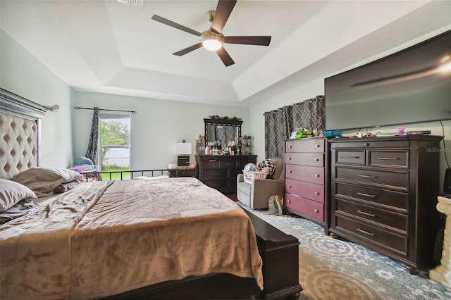 bedroom featuring ceiling fan and a raised ceiling