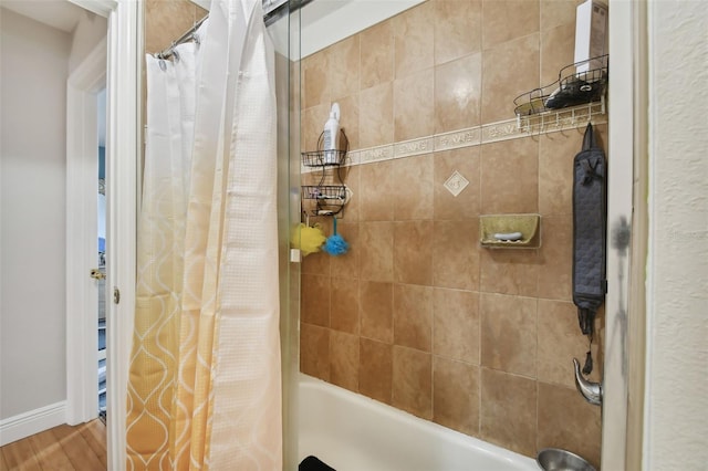 bathroom with shower / tub combo and wood-type flooring