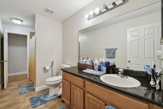 bathroom featuring vanity, tile patterned flooring, and toilet