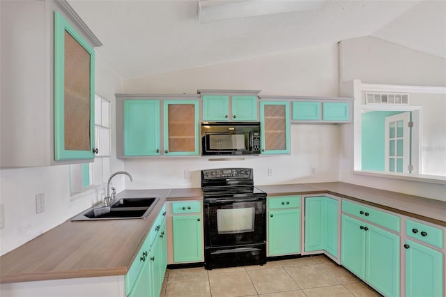1053 E Hancock Dr, Deltona, FL 32725 - kitchen featuring black appliances, vaulted ceiling, glass insert cabinets, and light tile patterned floors