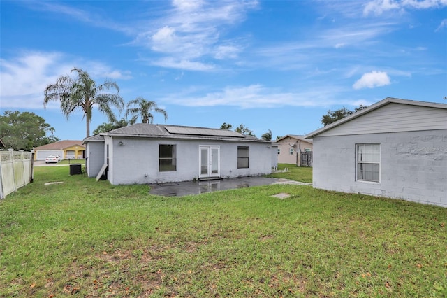 1053 E Hancock Dr, Deltona, FL 32725 - rear view of house with a patio, roof mounted solar panels, and french doors
