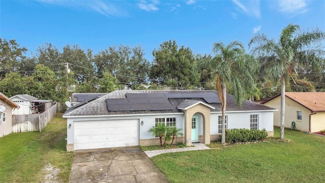 1053 E Hancock Dr, Deltona, FL 32725 - ranch-style house with brick siding, concrete driveway, an attached garage, a shingled roof, and roof mounted solar panels