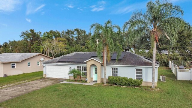 1053 E Hancock Dr, Deltona, FL 32725 - single story home with an attached garage, stucco siding, driveway, roof mounted solar panels, and a shingled roof