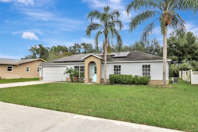 1053 E Hancock Dr, Deltona, FL 32725 - ranch-style home featuring a garage, brick siding, concrete driveway, stucco siding, and roof mounted solar panels