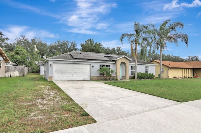 1053 E Hancock Dr, Deltona, FL 32725 - ranch-style house with solar panels, an attached garage, driveway, brick siding, and roof with shingles