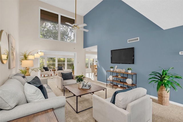 carpeted living room featuring a high ceiling and ceiling fan