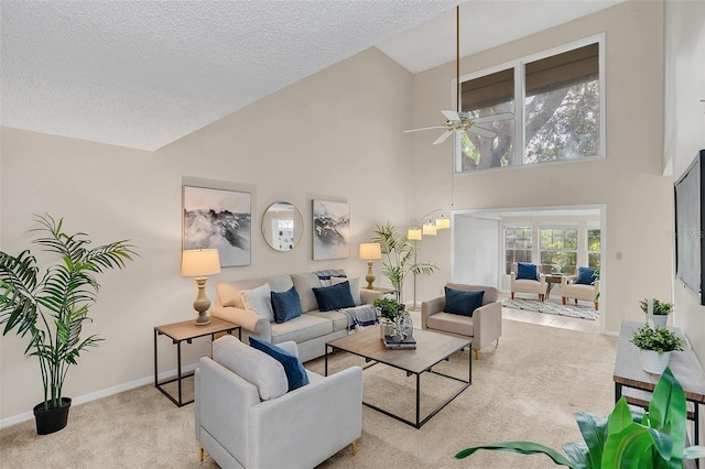 carpeted living room with ceiling fan, a high ceiling, and a textured ceiling