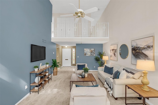 carpeted living room with a high ceiling and ceiling fan