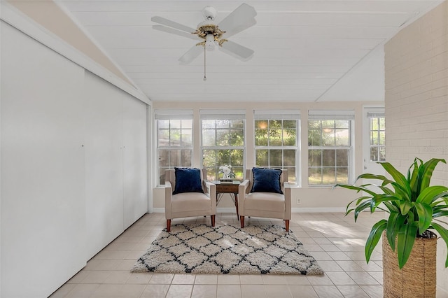 sunroom featuring ceiling fan, a wealth of natural light, and vaulted ceiling