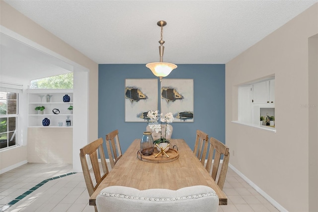 tiled dining space with built in shelves and a textured ceiling