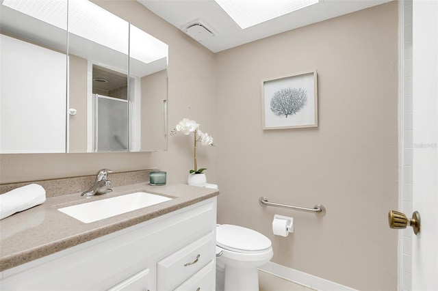 bathroom with toilet, walk in shower, a skylight, and vanity