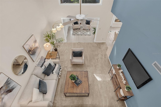 living room featuring a towering ceiling and ceiling fan