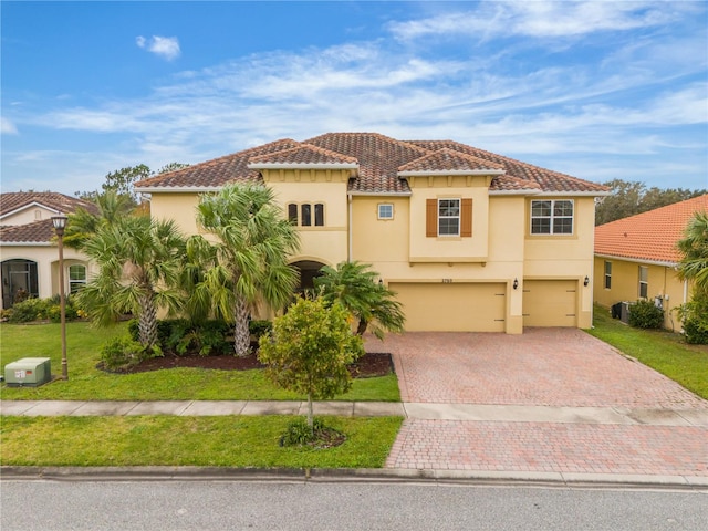 mediterranean / spanish house with a garage and a front yard