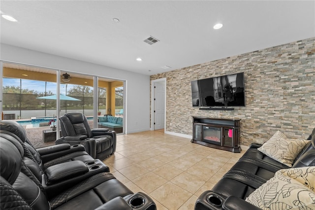 tiled living room featuring a stone fireplace