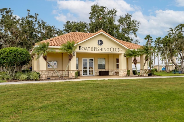 mediterranean / spanish-style home featuring a front lawn and french doors