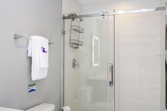 bathroom featuring toilet and an enclosed shower