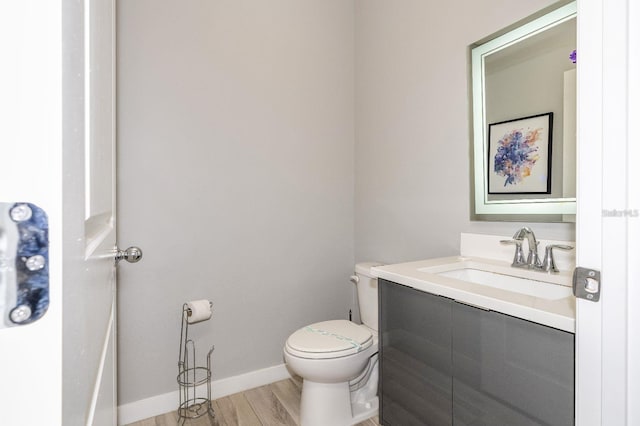 bathroom with wood-type flooring, vanity, and toilet