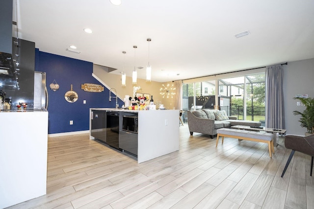 kitchen with an inviting chandelier, pendant lighting, and light hardwood / wood-style flooring