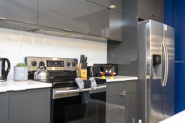 kitchen with decorative backsplash, appliances with stainless steel finishes, and gray cabinetry