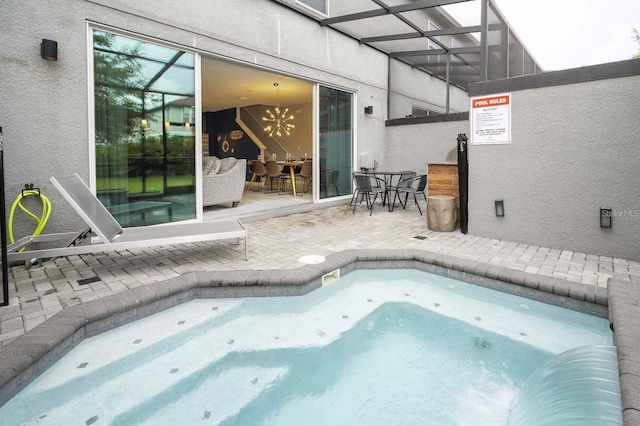 view of swimming pool with a lanai, an indoor hot tub, and a patio