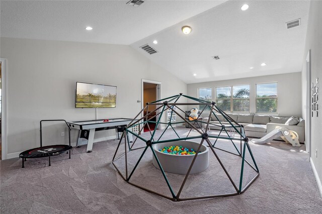 playroom featuring a textured ceiling, carpet floors, and lofted ceiling