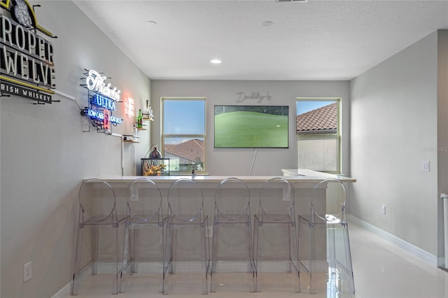 interior space with tile patterned flooring, a healthy amount of sunlight, and a textured ceiling