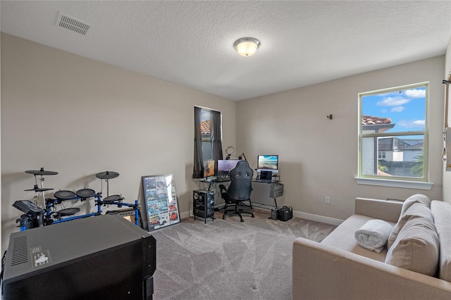 carpeted office space featuring a textured ceiling