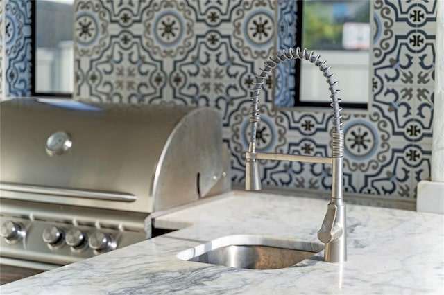 interior details with light stone countertops and sink