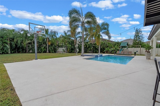 view of swimming pool featuring a lawn, basketball hoop, and a playground