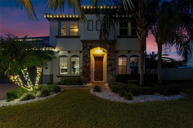 mediterranean / spanish house featuring a yard