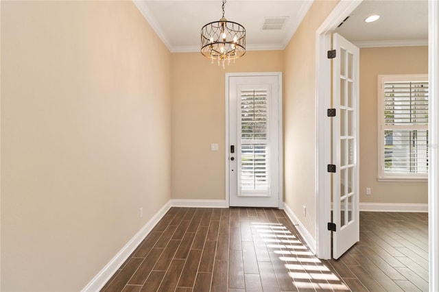 entryway with a notable chandelier and crown molding