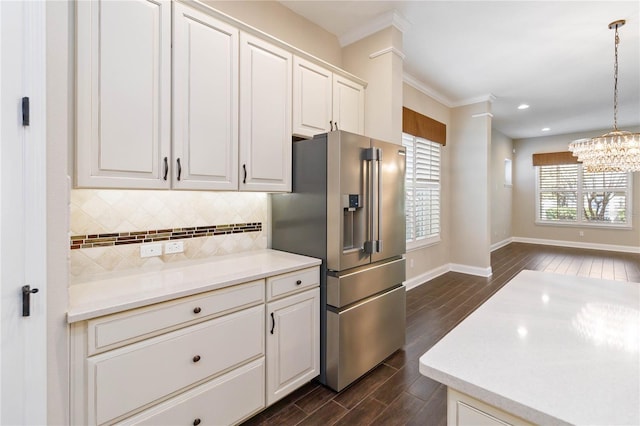 kitchen with white cabinets, crown molding, hanging light fixtures, decorative backsplash, and high quality fridge