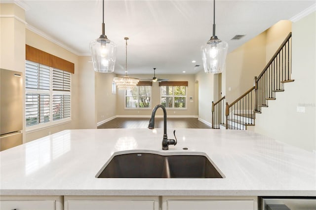 kitchen featuring ceiling fan, sink, a healthy amount of sunlight, hanging light fixtures, and crown molding